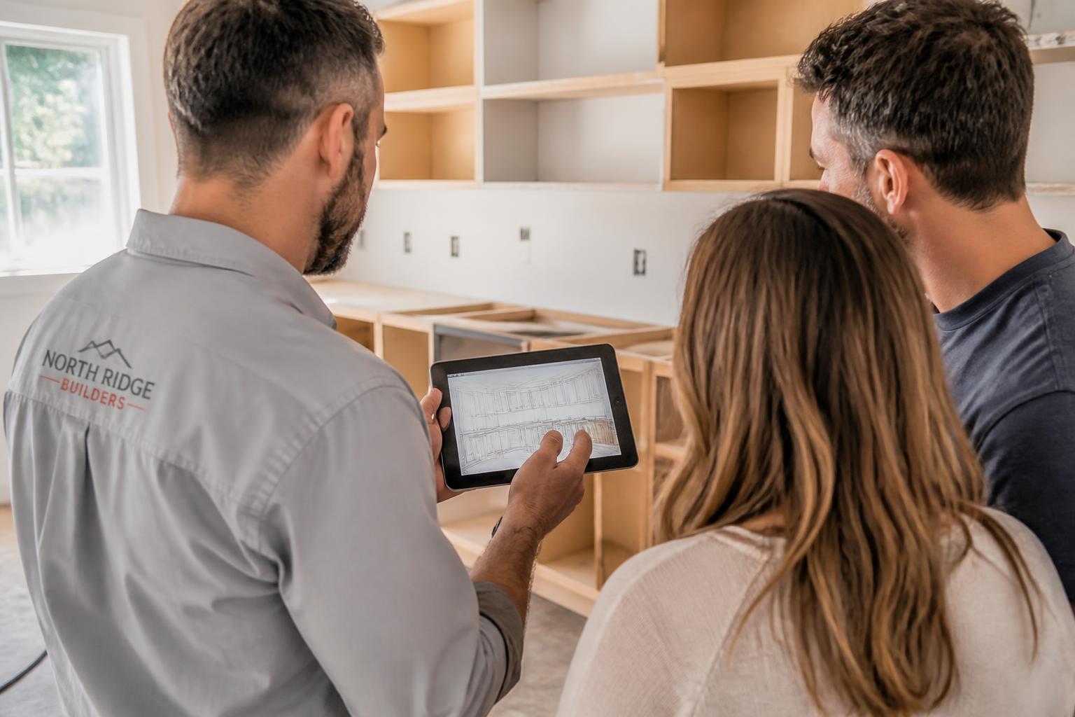 Contractor reviewing cabinet plans with a homeowner client